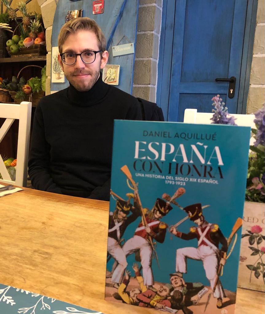 El historiador zaragozano Daniel Aquillué y su última obra, 'España con honra'. FOTO: La Esfera de Libros