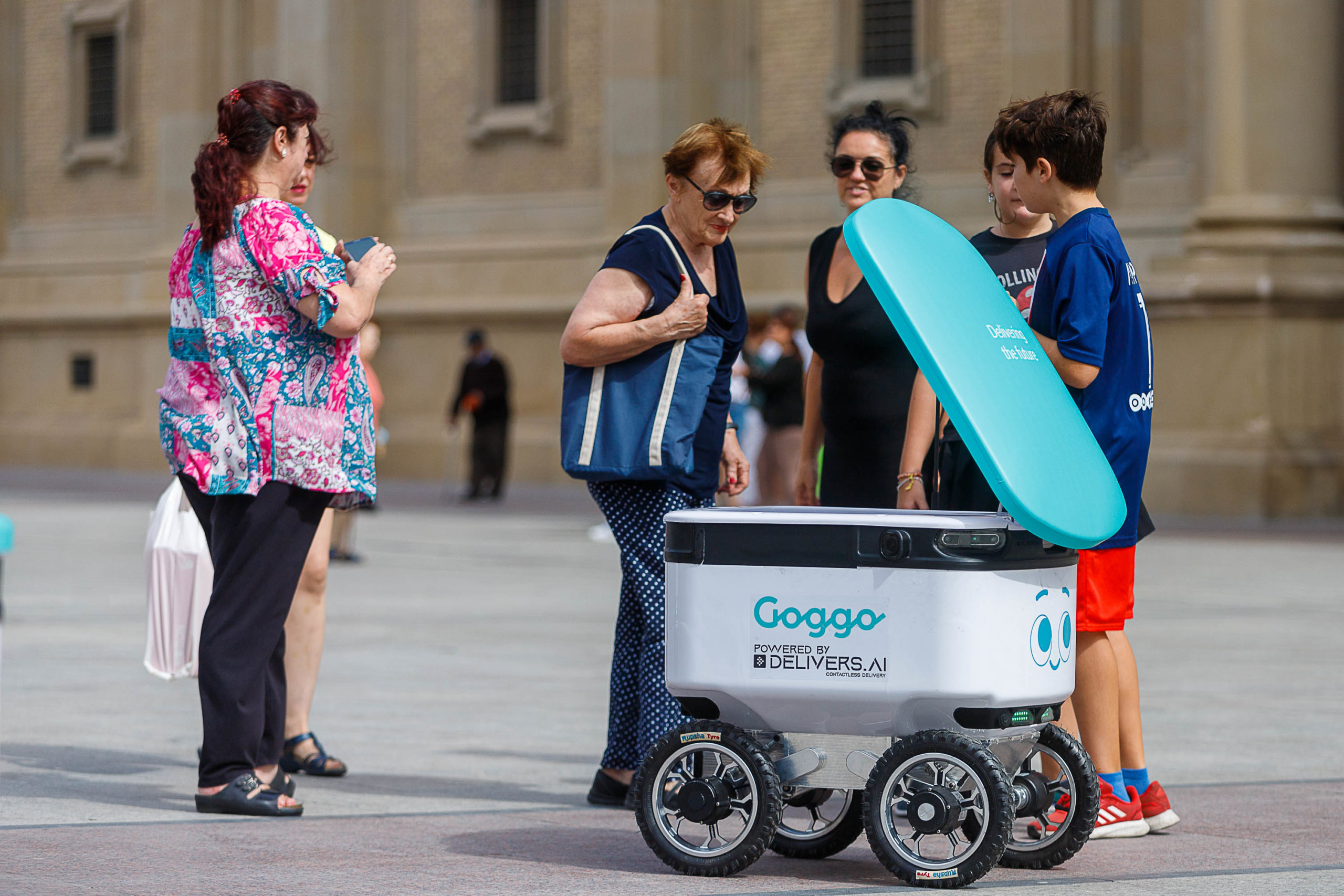 Varias personas observan el robot autónomo de Goggo que recorre las calles de Zaragozan en su presentación. FOTO: Ayuntamiento de Zaragoza